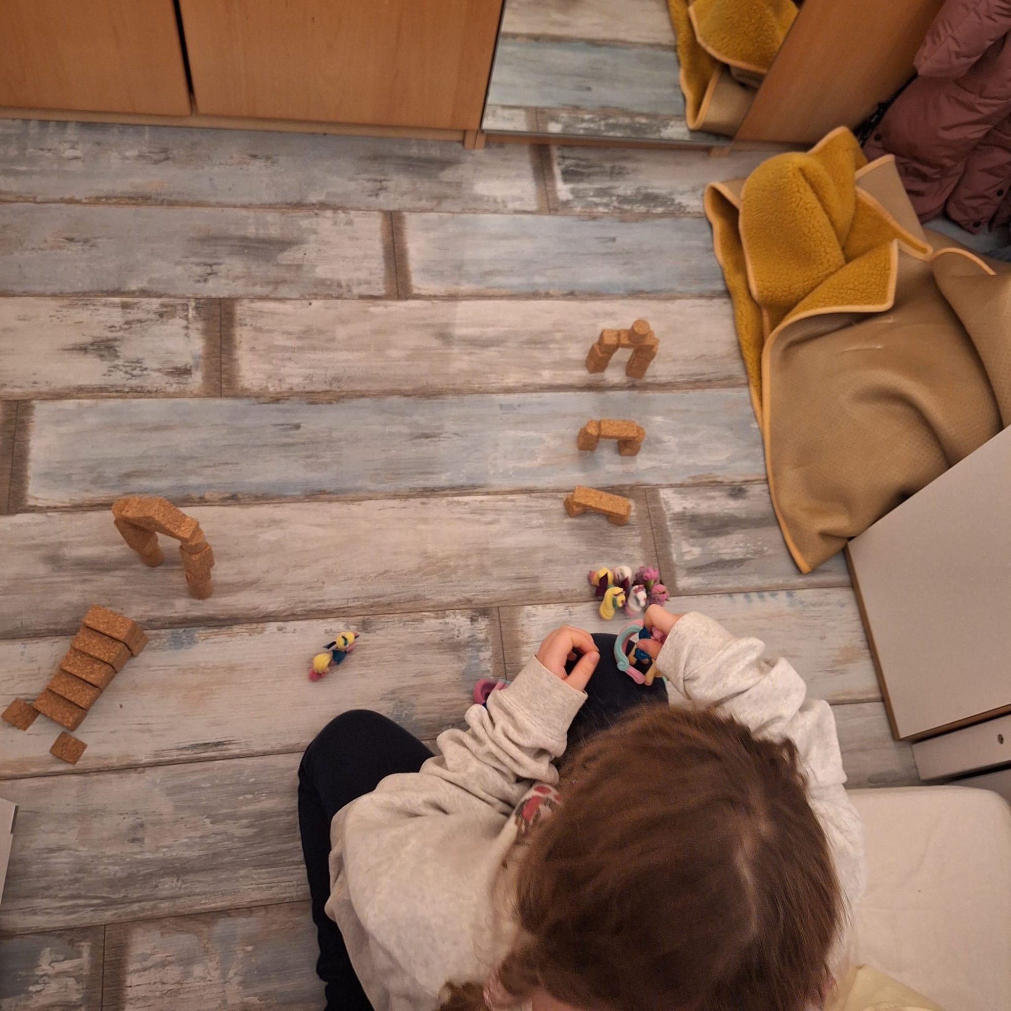 Kind spielt konzentriert mit Korkino Korkbausteinen aus Naturkork. Das geräuscharme Spielmaterial fördert freies Spiel, Kreativität und die motorische Entwicklung.